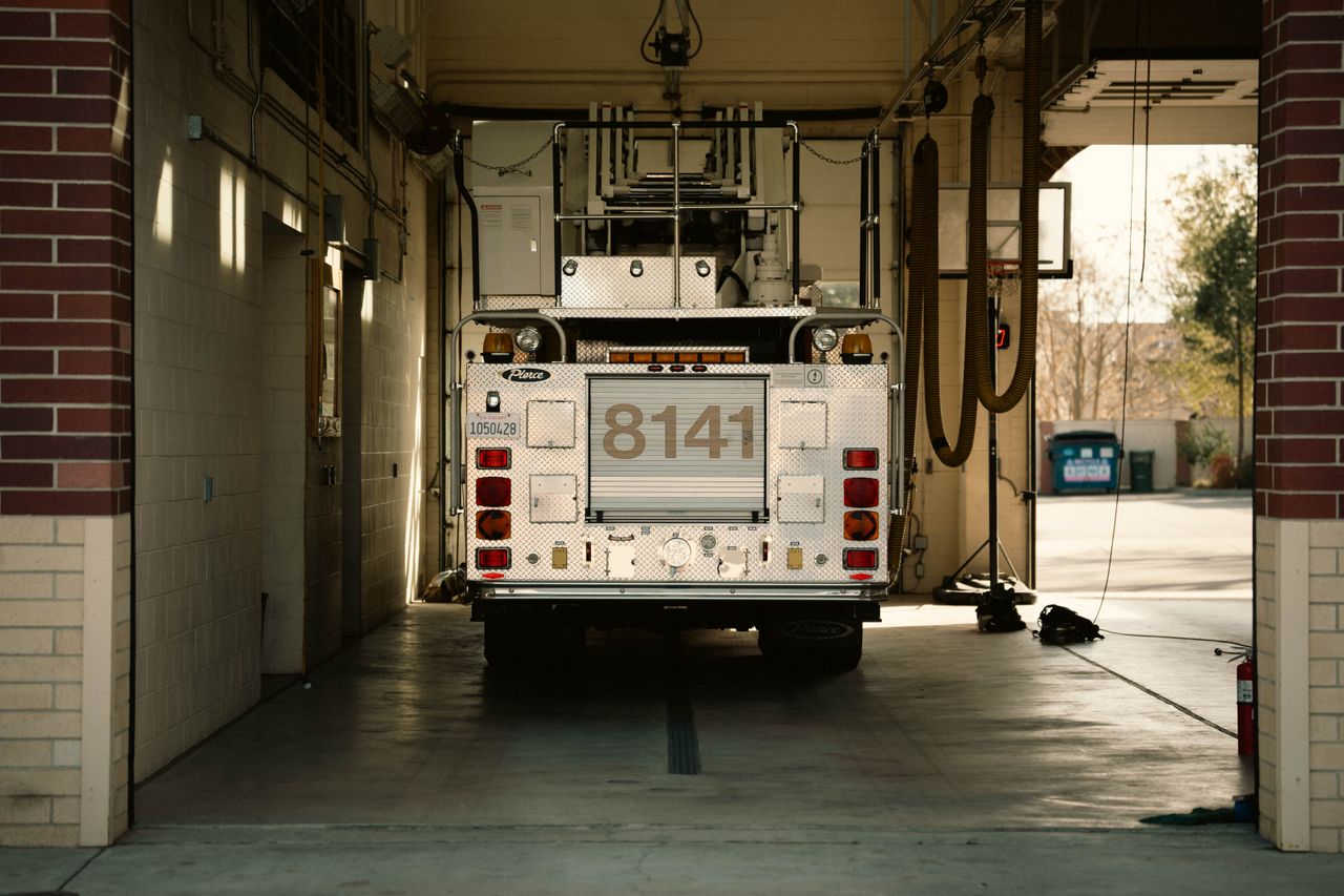 Home A fire truck parked inside a station's garage, showcasing emergency preparedness.