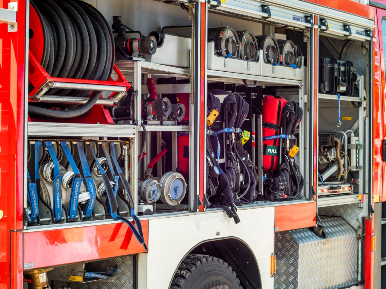 Services Close-up view of fire truck equipment storage showcasing hoses, tools, and gear.